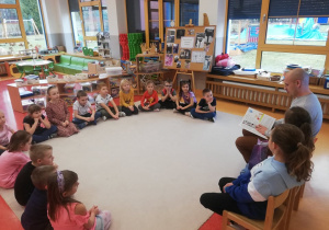 dzieci siedzą i słuchają opowiadania